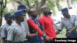 FILE - Activist Itai Dzamara, center left in red and blue, is detained by police in Zimbabwe in this undated photo and has been missing since 2015.