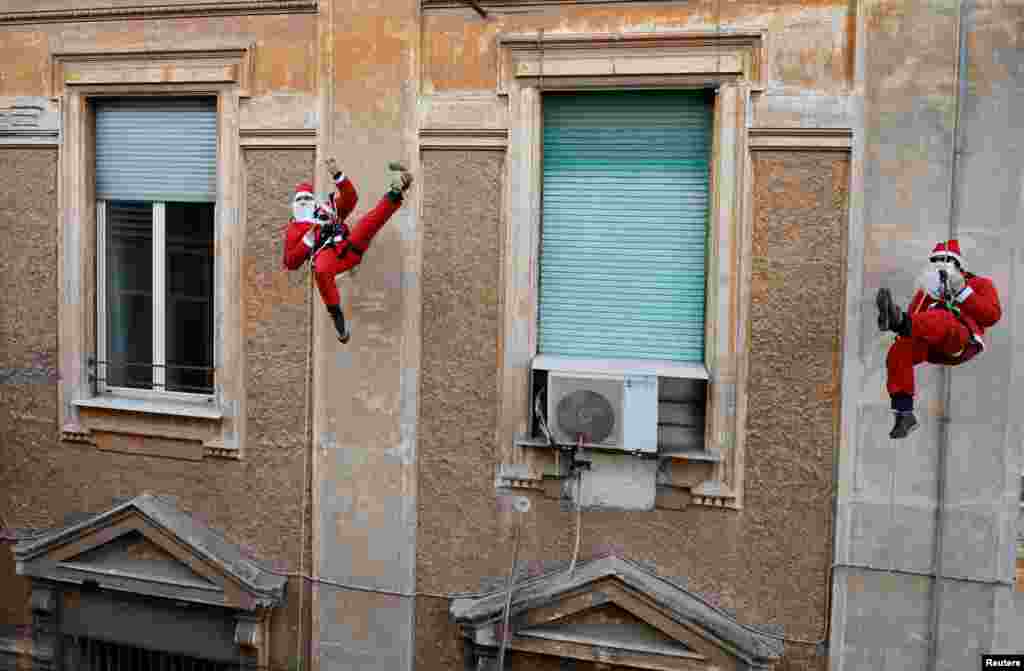 Alpine Rescue Team members dressed as Santa Claus rappel down the Policlinico Umberto I Hospital to greet children hospitalized in the pediatric ward in Rome, Italy.