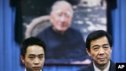Bo Xilai (R) and his son, Bo Guagua, stand in front of a picture of his father Bo Yibo, a former top Communist party official, in Beijing, January 18, 2007. 