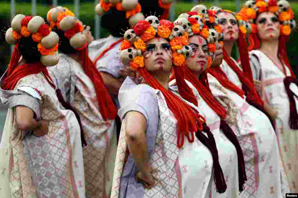 Women dressed up as "Catrinas," a Mexican character also known as "The Elegant Death," participate in a procession to commemorate Day of the Dead in Mexico City, Oct. 28, 2017.