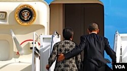 Presiden Barack Obama dan ibu negara Michelle Obama saat menaiki tangga pesawat untuk menuju Honolulu, Hawaii (11/11).