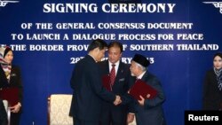 Secretary-General of Thailand's National Security Council, Paradorn Pattanathabutr, center left, shakes hands with chief of Thailand's National Revolution Front (BRN) liaison office in Malaysia, Hassan Taib, center right, Kuala Lumpur, Feb. 28, 2013.