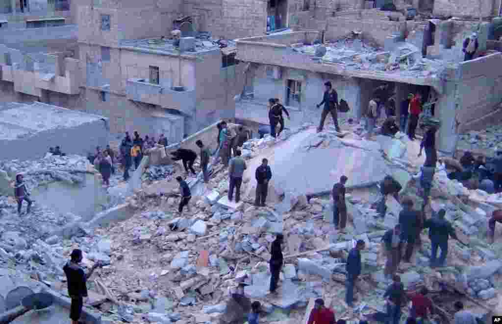 This citizen journalism image provided by the Aleppo Media Center shows Syrians searching for dead bodies in the rubble of buildings hit by Syrian airstrikes, Aleppo, March 20, 2013.