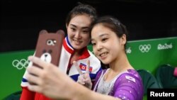 Lee Eun-Ju (KOR) of South Korea (R) takes a selfie picture with Hong Un Jong (PRK) of North Korea.