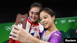 Lee Eun-Ju (KOR) of South Korea (R) takes a selfie picture with Hong Un Jong (PRK) of North Korea.