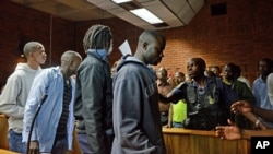 Les suspects non identifiés laissant le tribunal, à Prétoria, le 7 fév. 2013