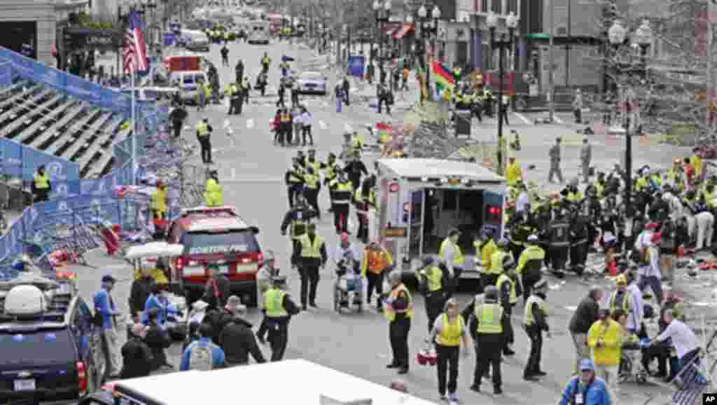 Param&eacute;dicos ajudam feridos junto &agrave; linha de chegada da Maratona de Boston 2013, ap&oacute;s as explos&otilde;es no dia 15 de Abril de 2013.