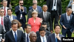 German Chancellor Angela Merkel (C) and U.S. President Barack Obama arrive with other G7 participants for a family picture at the G7 summit at the Elmau castle in Kruen near Garmisch-Partenkirchen, Germany, June 8, 2015. 