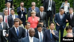 German Chancellor Angela Merkel (C) and U.S. President Barack Obama arrive with other G-7 participants for a group photo at the G-7 summit at the Elmau castle in Kruen near Garmisch-Partenkirchen, Germany, June 8, 2015.