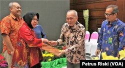 Wiratno, Dirjen Konservasi Sumber Daya Alam dan Ekosistem (KSDAE) KLHK (kanan), menyerahkan SK Izin Lembaga Konservasi untuk Kebun Binatang Surabaya kepada Wali Kota Surabaya Tri Rismaharini di Surabaya, 24 Mei 2019. (Foto: Petrus Riski/VOA)