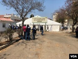 Reporters wait outside Zimbabwe's Constitutional Court in Harare, Aug. 22, 2018, where a presidential election challenge filed by the country's main opposition group was being heard. (C. Mavhunga/VOA)