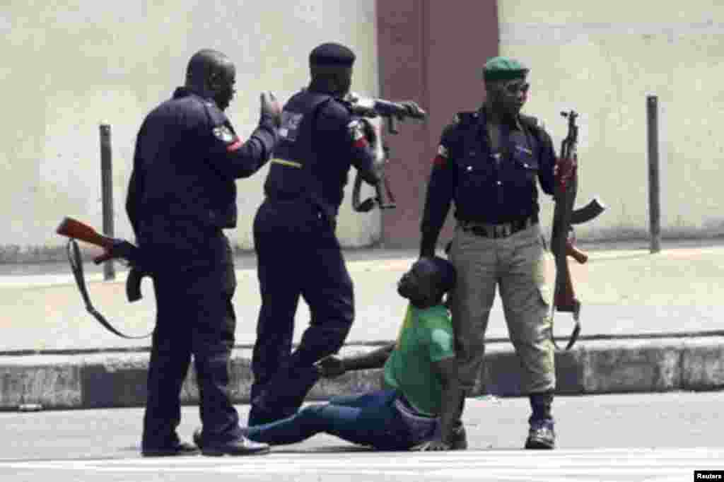 Policemen beat up a protester during a rally against fuel subsidy removal on Ikorodu road in Nigeria's commercial capital Lagos January 3, 2012. Hundreds of demonstrators in Nigeria's commercial capital Lagos shut petrol stations, formed human barriers al