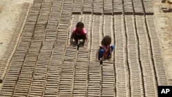 FILE - Indian children work at a brick factory on the outskirts of Jammu, May 1, 2018.