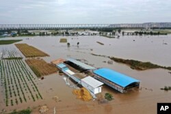 Sungai Kuning di dekat Desa Lianbo di Kota Hejin, Provinsi Shanxi, China utara, tampak meluap pada Minggu, 10 Oktober 2021. (Foto: via AP)