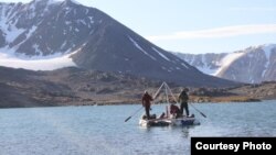 From this small platform perched atop two inflatable rafts, these scientists are able to take sediment cores from the lake floor below. (Credit: Marthe Gjerde)