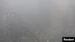 FILE - Cars drive on Three Ring Road amid a heavy haze in Beijing.