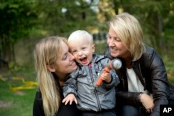 Albin's mother Emelie Eriksson, left, poses for a photo with her son and her mother Marie, right, outside her home in Bergshamra, Sweden, Sept. 20, 2016. For Emelie Eriksson, the bond she shares with her son Albin is particularly unique: both Emelie and Albin were born from the same womb, after Emelie received her mother’s transplanted uterus in a revolutionary operation that links three generations of their family.