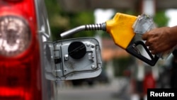 A worker fills a tank with subsidized fuel at a fuel station in Jakarta, April 18, 2013. 