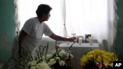 Woman arranges altar at the home of journalist Juan Mendoza Delgado as relatives wait for the arrival of the coffin containing his remains, Medellin, state of Veracruz, Mexico, July 3, 2015.