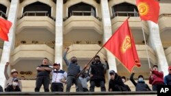 Supporters of Kyrgyzstan's Prime Minister Sadyr Japarov attend a rally in Bishkek, Kyrgyzstan, Oct. 15, 2020. Kyrgyzstan President Sooronbai Jeenbekov announced his resignation in a bid to end the turmoil that has engulfed the Central Asian nation. (AP Photo/Vladimir Voronin)