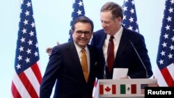 FILE - U.S. Trade Representative Robert Lighthizer embraces Mexican Economy Minister Ildefonso Guajardo during a joint news conference on the closing of the seventh round of NAFTA talks in Mexico City, March 5, 2018.