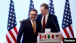 FILE - U.S. Trade Representative Robert Lighthizer embraces Mexican Economy Minister Ildefonso Guajardo during a joint news conference on the closing of the seventh round of NAFTA talks in Mexico City, March 5, 2018.