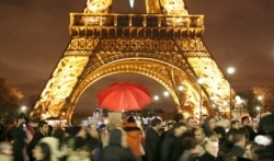 Penonton berkumpul di depan menara Eiffel selama perayaan malam Tahun Baru. (Foto: REUTERS/Charles Platiau)