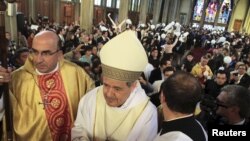 FILE - Bishop Juan Barros, center, attends his first religious service as citizens, rear right, protest against him at the Osorno cathedral, south of Santiago, March 21, 2015. 