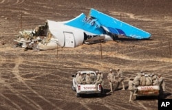 Egyptian Military in cars approach a plane's tail at the wreckage of a passenger jet bound for St. Petersburg in Russia that crashed in Hassana, Egypt, on Nov. 1, 2015.