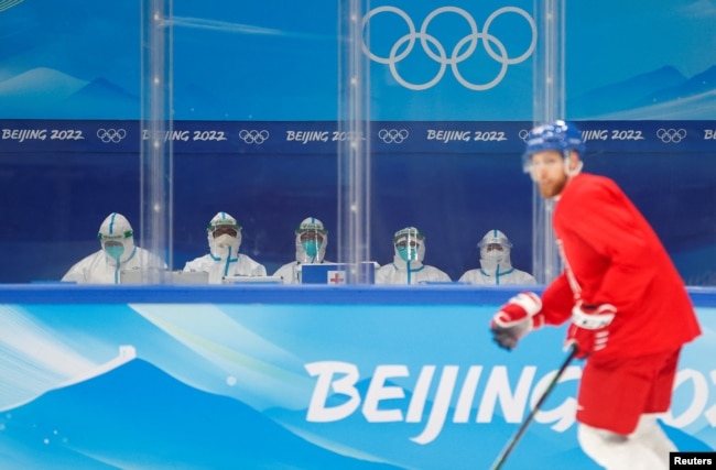 Tenaga medis mengenakan alat pelindung diri (APD) duduk di sisi arena saat tim hoki es Ceko berlatih di Stadion Indoor Nasional jelang Olimpiade Musim Dingin Beijing 2022 di Beijing, China, 1 Februari 2022. (Foto: REUTERS/David W Cerny)
