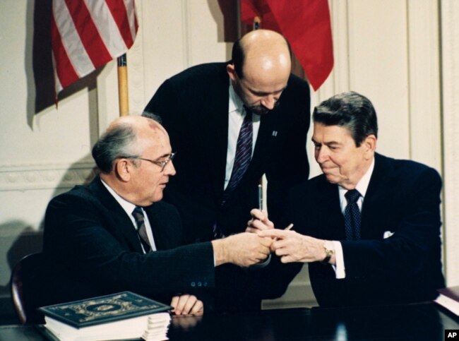1987年12月8日美国总统里根（右）与苏联领导人戈尔巴乔夫签署《中导条约》后交换签字笔