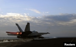 A U.S. Navy handout photo dated February 13, 2012 shows a F/A-18E Super Hornet fighter jet launching from the flight deck of the aircraft carrier USS Abraham Lincoln, part of the Bahrain-based U.S. 5th Fleet.