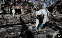 Forensics experts gather evidence in the rubble of a funeral hall destroyed by a deadly Saudi-led airstrike on Oct. 8, 2016, in Sanaa, Yemen.