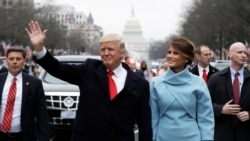 President Donald Trump waves as he walks with first lady Melania Trump and son Baron during the inauguration parade on Pennsylvania Avenue in Washington, Jan. 20, 2017. 