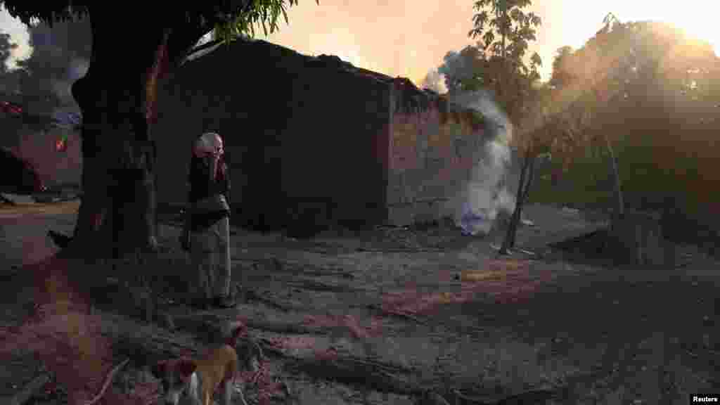 A woman looks at burning houses in Bossangoa, north of Bangui, Jan. 3, 2014.