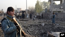 Afghan security members inspect the site of a suicide car bombing at Surkh Rud district in Nangarhar province, east of Kabul, Afghanistan, Dec. 7, 2015.