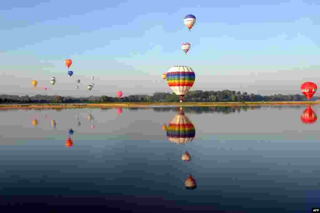 Hot air balloons fly over the Loire during the 39th French Air-Balloon Championship in Brissac-Quincé, Western France. Ninety-two hot-air balloons compete until Aug. 31.