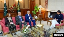 FILE - Pakistani Prime Minister Imran Khan (R) speaks with U.S. special envoy Zalmay Khalilzad (3rd L) during a meeting at the Prime Minister's office in Islamabad, Pakistan, in this handout photo released Jan. 18, 2018.