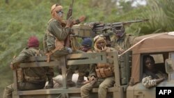 Malian soldiers patrol aboard a vehicle mounted with a machine gun in a street of Diabaly (400km north of the capital Bamako), January 26, 2013. 