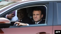 French President Emmanuel Macron, right, and Kenyan President Uhuru Kenyatta take a test drive during the presentation of the new Peugeot 3008 Allure SUV at the State House in Nairobi, March 13, 2019.