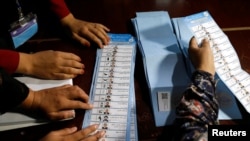 Los trabajadores de la comisión electoral afgana cuentan las papeletas de las elecciones presidenciales en Kabul, Afganistán, 28 de septiembre de 2019.