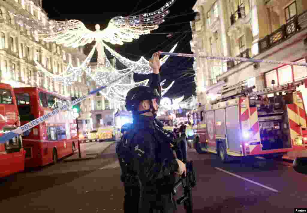 An armed police officer ducks under police tape on Oxford Street, London, Britain, Nov. 24, 2017. 