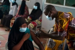 FILE - A health worker administers a dose of the Johnson & Johnson COVID-19 vaccine at the Bundung Maternal and Child Health Hospital, in Serrekunda, outskirts of Banjul, Gambia, Sept. 23, 2021.
