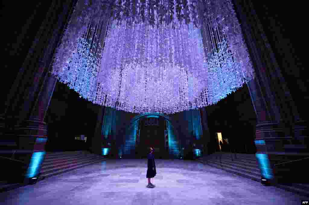 An assistant stands beneath a mass participation art installation entitled Peace Doves, which was created by sculptor Peter Walker, in Liverpool Cathedral, Liverpool, north west England.