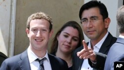 Facebook founder and CEO Mark Zuckerberg (L) and Colombian Minister of Information Technologies and Communications Diego Molano pose for photographers outside the presidential palace in Bogota, Jan. 14, 2015.