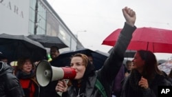 Women shout slogans as they march through the downtown in a protest against efforts by the nation's conservative leaders to tighten Poland's already restrictive abortion law, in Warsaw, Poland, Oct. 3, 2017.