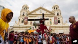 FILE - Devotees carry a replica of the Black Nazarene during the traditional blessing outside the Quiapo church in downtown Manila, Philippines, January 4, 2024.