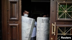 After storming the prosecutor's office, pro-Russia activists stand guard with officers' shields at the entrance in Donetsk, Ukraine, May 1, 2014. 