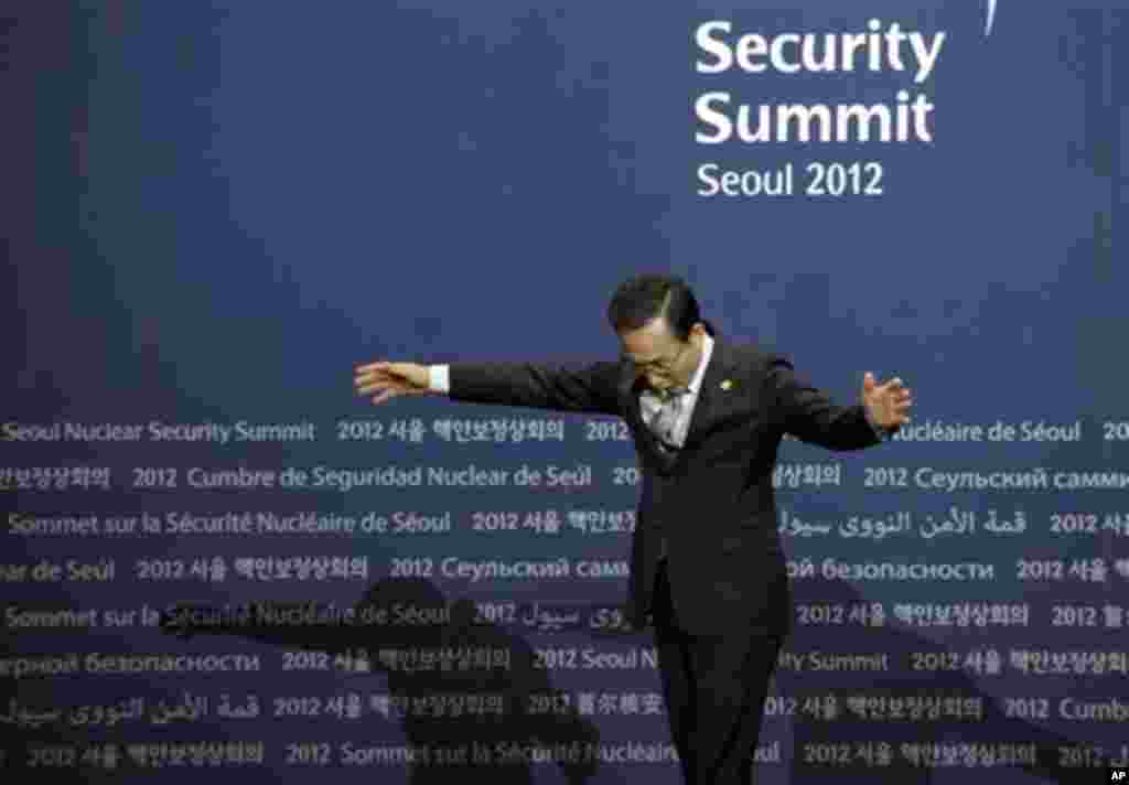 South Korean President Lee Myung-bak looks for his toe marks as he waits for leaders to arrive for a welcome ceremony for the Nuclear Security Summit at the Coex Center, in Seoul, South Korea, Monday, March 26, 2012. (AP Photo/Susan Walsh)