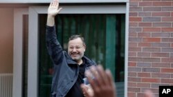 Ahmed Mansour waves as he leaves the security checkpoint of the Moabit jail in Berlin, Germany, June 22, 2015.